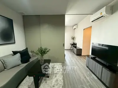 Modern living room with sleek furniture and air conditioning, featuring a stylish sliding door and elegant decor.