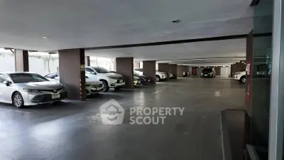 Spacious indoor parking area with multiple cars in a modern building.
