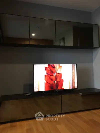 Modern living room with sleek mirrored cabinets and stylish TV setup