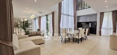 Luxurious open-plan living and dining area with high ceilings and elegant decor.