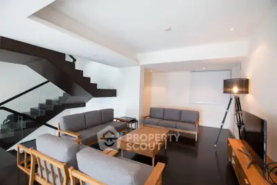Modern living room with sleek staircase and stylish furniture