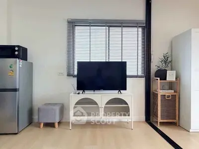 Modern living room with TV, fridge, and stylish decor