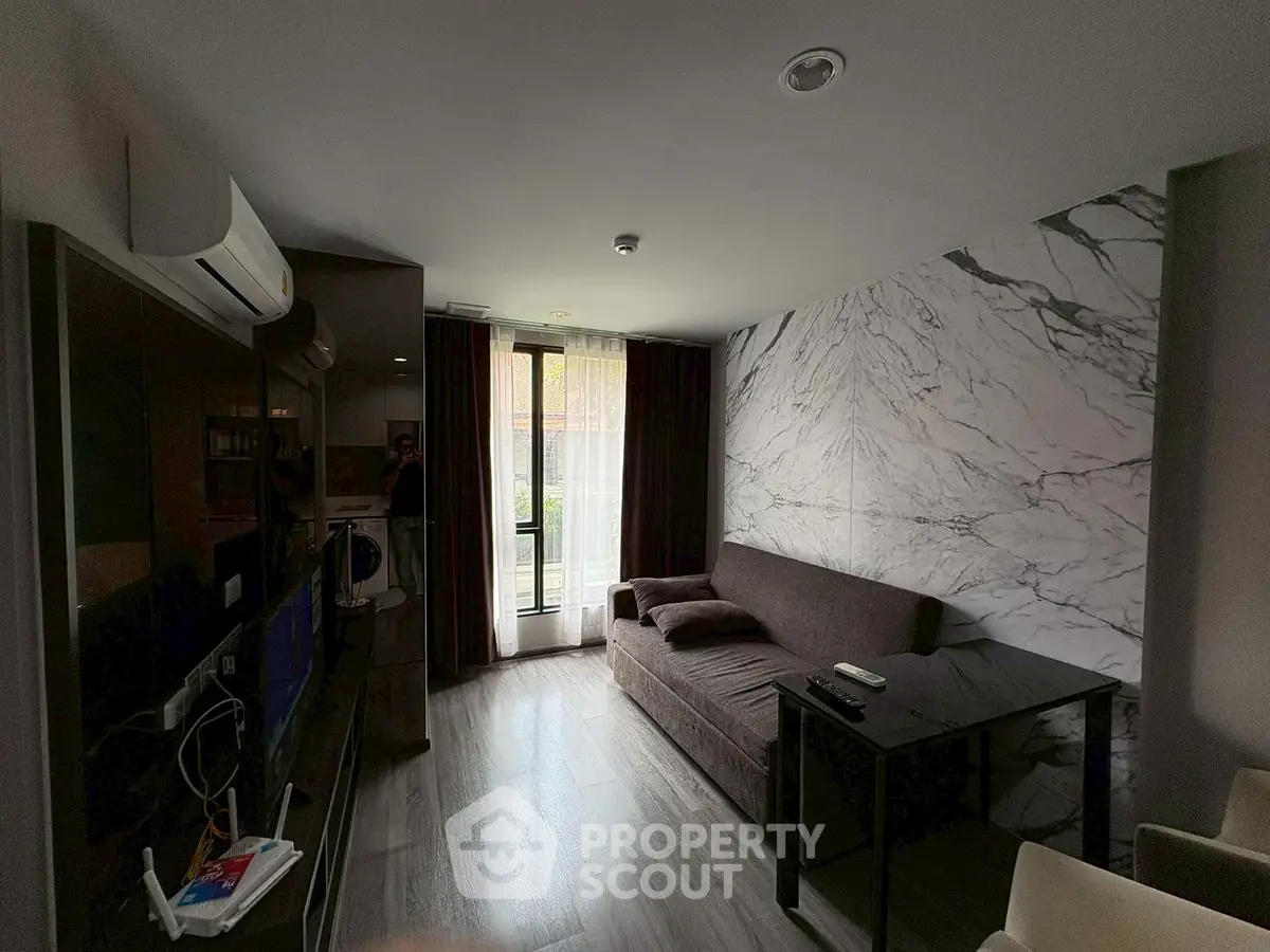 Modern living room with marble accent wall and natural light