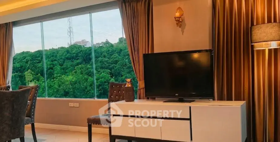 Luxurious living room with stunning forest view through large windows, elegant decor, and modern furnishings.