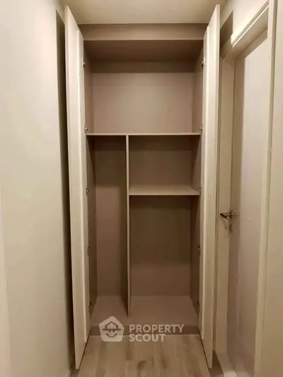 Spacious built-in closet with open shelving in modern apartment interior.