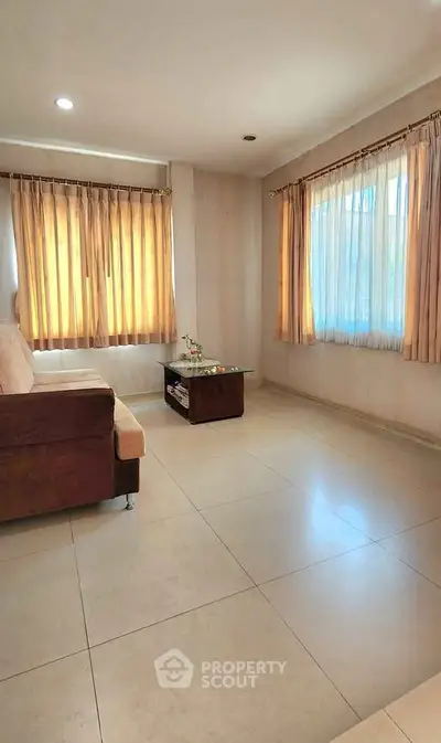 Bright and spacious living room with large windows and modern furniture.