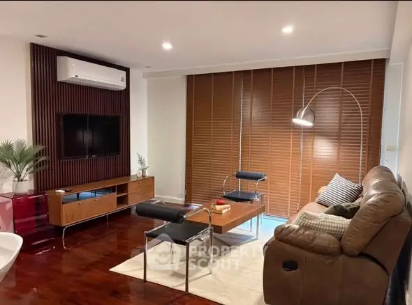 Stylish living room with modern furniture and wooden flooring, featuring a cozy ambiance.