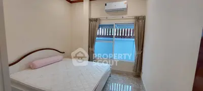 Cozy bedroom with air conditioning and natural light, perfect for relaxation.