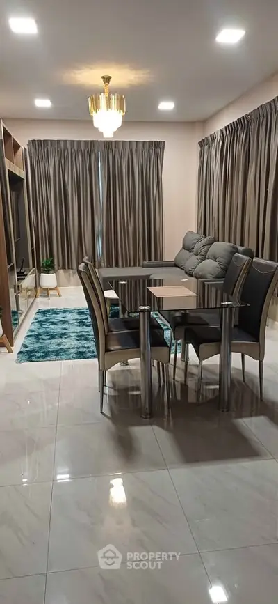 Elegant living room with modern dining set and plush sofa, featuring chic curtains and ambient lighting.