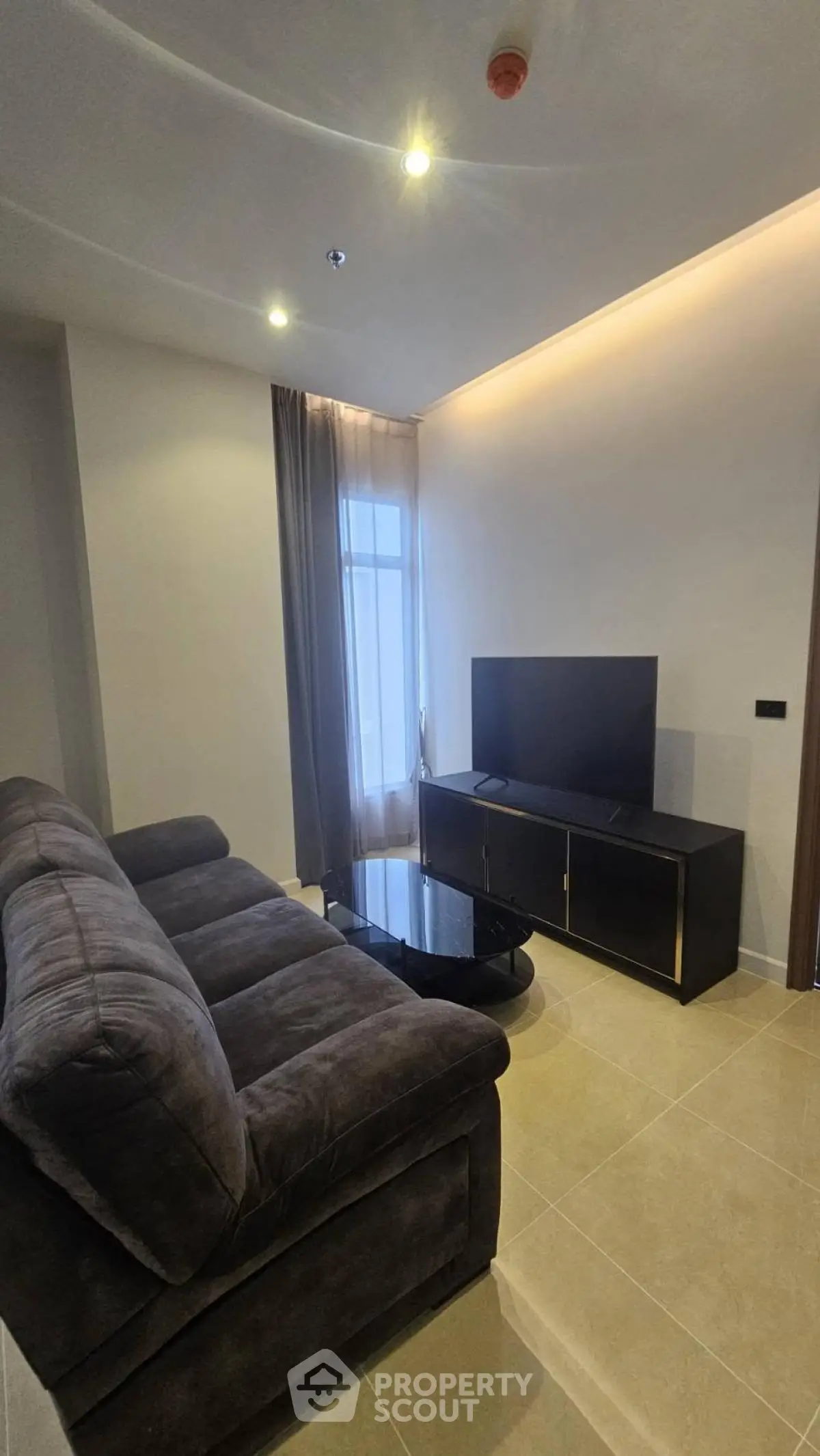 Modern living room with plush sofa and sleek TV unit in a stylish apartment.