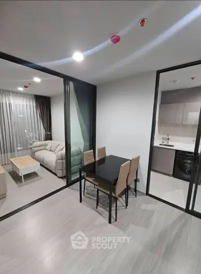 Modern apartment with open layout, featuring a cozy living room and dining area with sleek furnishings.