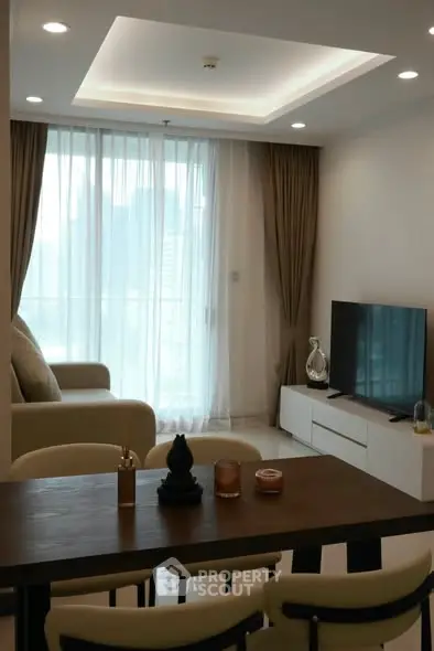 Modern living room with large windows and stylish furniture, perfect for relaxation and entertainment.