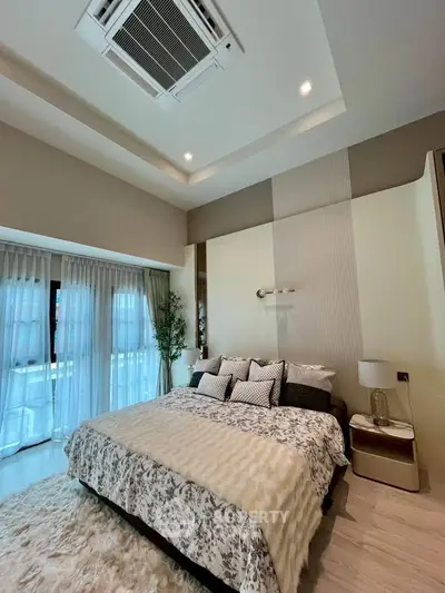 Luxurious bedroom with elegant decor and large windows for natural light.