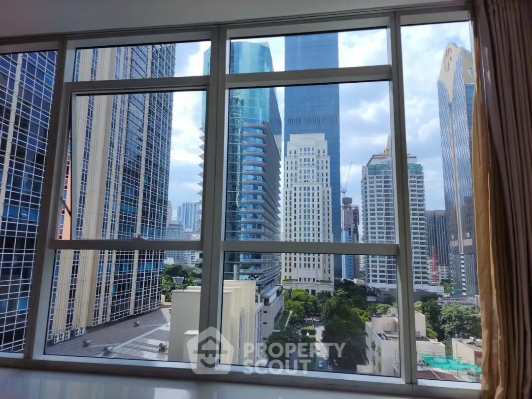 Stunning cityscape view from a high-rise apartment window, showcasing modern skyscrapers and urban skyline.