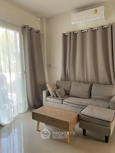 Cozy living room with modern sofa and air conditioning, perfect for relaxation.