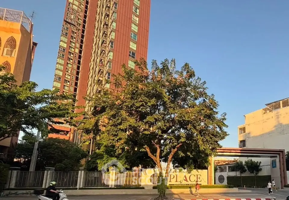 Stunning high-rise building with lush greenery and clear blue sky, perfect for urban living.