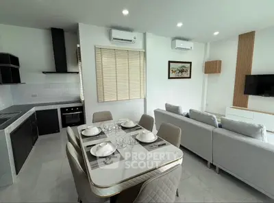 Modern open-plan kitchen and living room with sleek design and dining area.