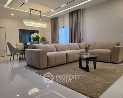 Luxurious modern living room with elegant chandelier and plush sofas in a spacious open layout.