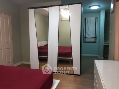 Spacious bedroom with mirrored wardrobe and modern decor