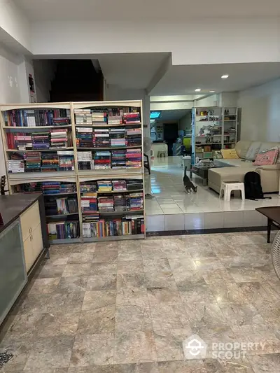 Spacious living room with bookshelves and cozy seating area, perfect for relaxation and reading.