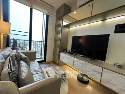Modern living room with sleek design, large TV, and balcony view in a stylish apartment.