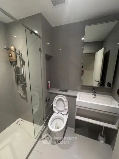 Modern bathroom with sleek design, featuring a glass shower and contemporary fixtures.