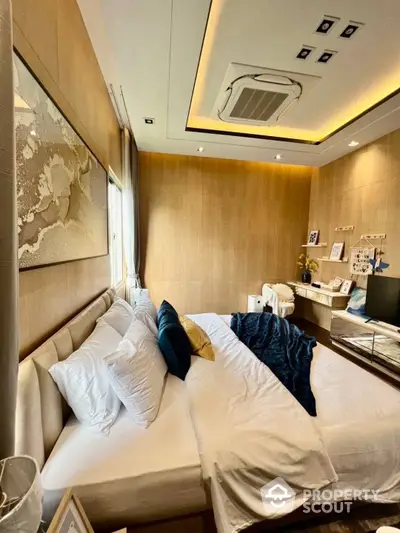 Luxurious bedroom with plush bedding, elegant wood paneling, and modern ceiling design, complemented by a cozy study area and ambient lighting.