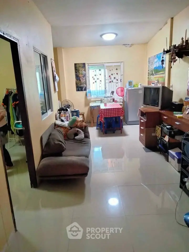 Cozy living room with dining area and modern appliances in a compact apartment.