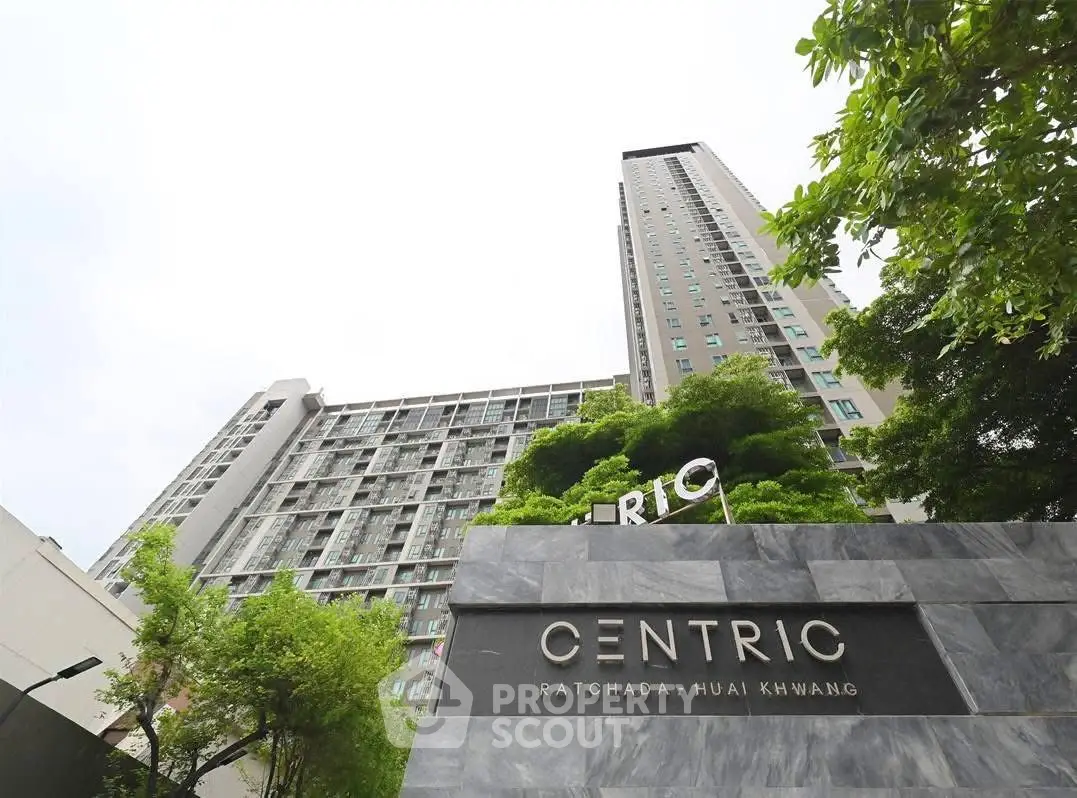 Modern high-rise building with lush greenery at Centric Ratchada Huai Khwang