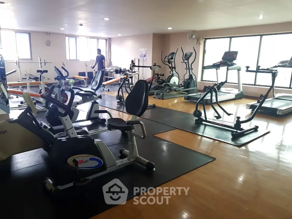 Spacious gym with modern exercise equipment and natural light