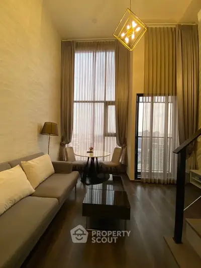 Luxurious high-ceiling living room with elegant decor and floor-to-ceiling windows.