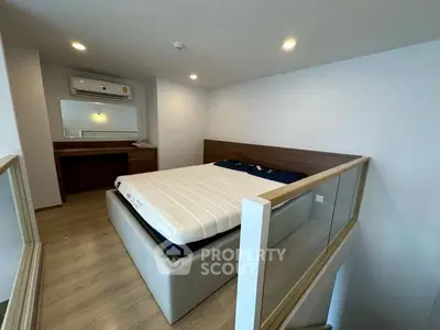 Modern bedroom with wooden flooring and glass railing, featuring a cozy bed and air conditioning.