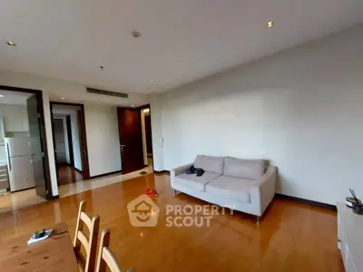 Spacious living room with wooden flooring and modern furniture in a stylish apartment.