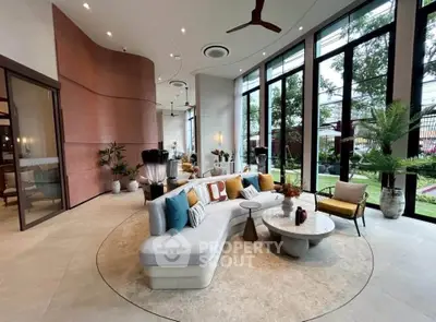 Luxurious modern living room with large windows and stylish decor, offering a serene garden view.
