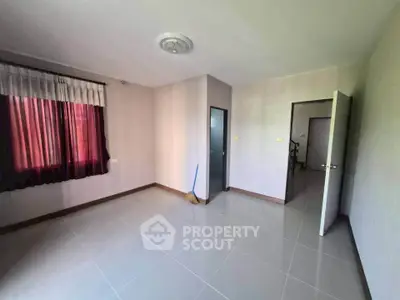 Spacious empty room with tiled floor and natural light, ideal for customization.