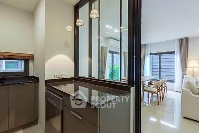 Modern kitchen with sleek design and open layout leading to a bright living area.