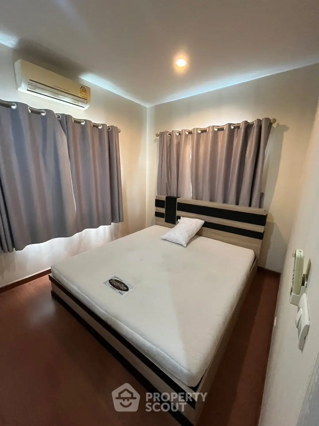 Cozy bedroom with modern bed and air conditioning, perfect for restful nights.