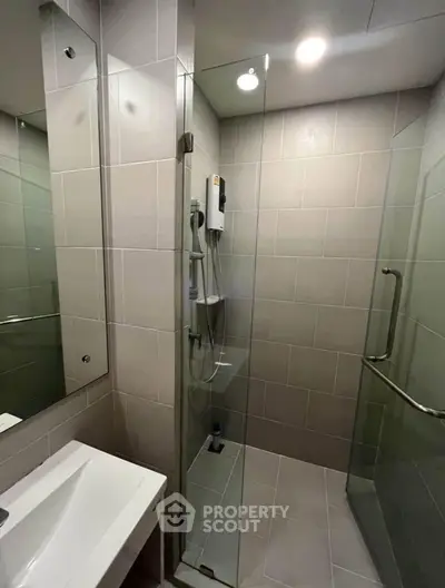 Modern bathroom with glass shower enclosure and sleek fixtures