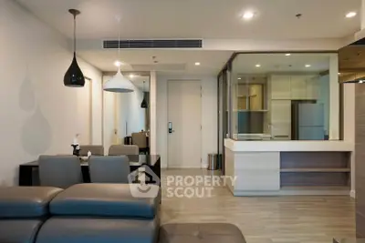 Modern open-plan living room with sleek kitchen and stylish lighting