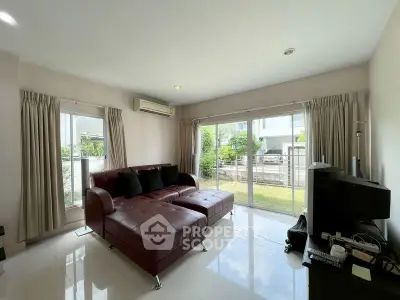 Spacious living room with modern furniture and garden view, perfect for relaxation and entertainment.