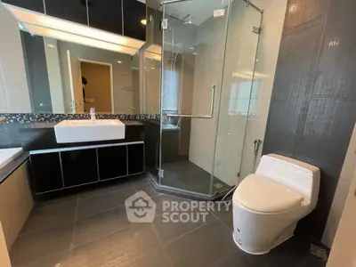 Modern bathroom with glass shower and sleek fixtures in a contemporary apartment.