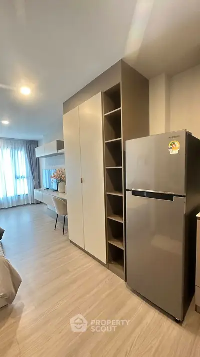 Modern apartment interior with sleek furniture and stainless steel fridge