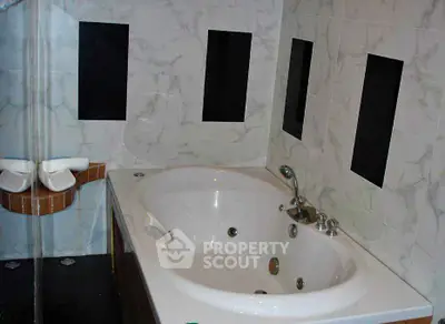 Luxurious bathroom with a stylish bathtub and modern tile design.