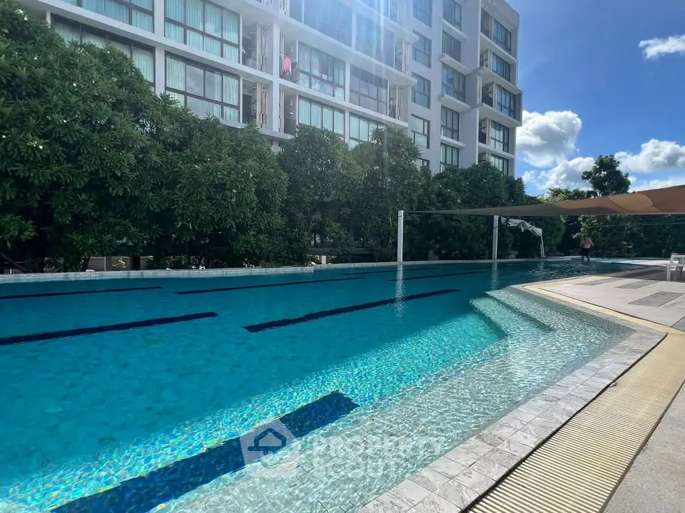 Luxurious residential building with a stunning outdoor pool and lush greenery, perfect for relaxation.