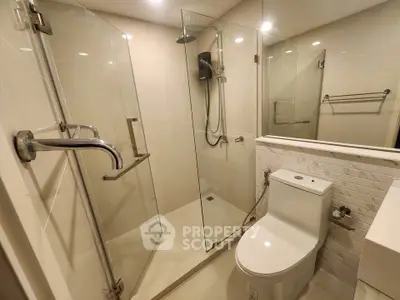 Modern bathroom with glass shower and sleek fixtures in a contemporary apartment.