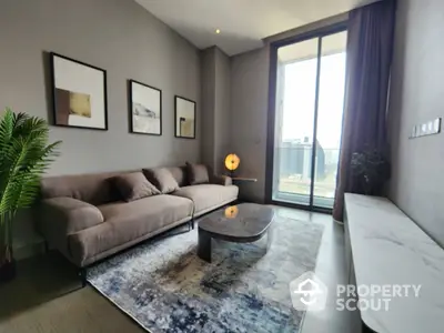 Elegant living room with plush sofa, modern coffee table, and large windows leading to a sunny balcony, perfect for relaxation and entertaining guests.