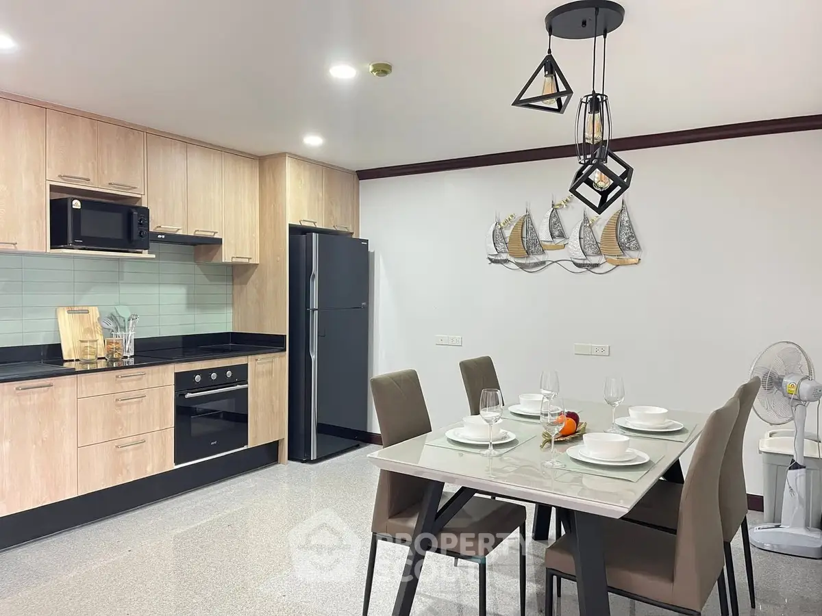 Modern kitchen with dining area, featuring sleek appliances and stylish decor.