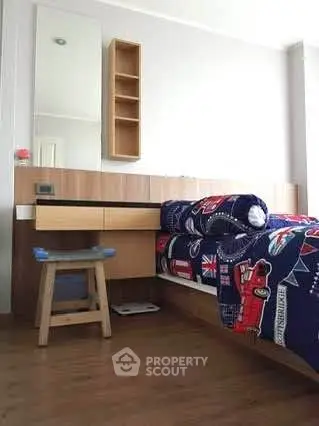 Cozy bedroom with stylish wooden furniture and vibrant bedding, perfect for a comfortable living space.