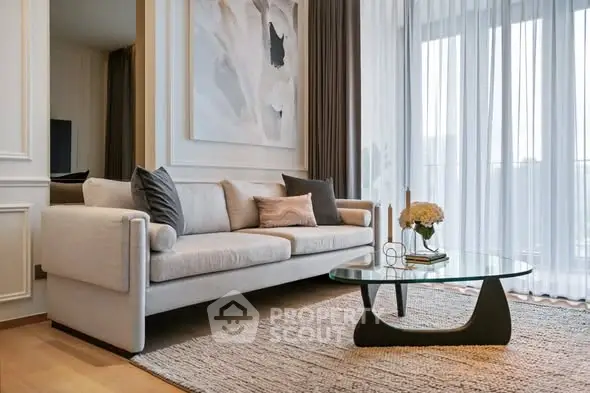Elegant living room with modern sofa and glass coffee table, featuring floor-to-ceiling windows.