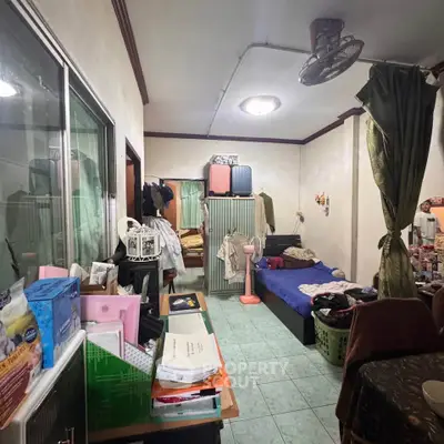 Cozy bedroom with cluttered decor and simple furnishings, ideal for budget-conscious living.